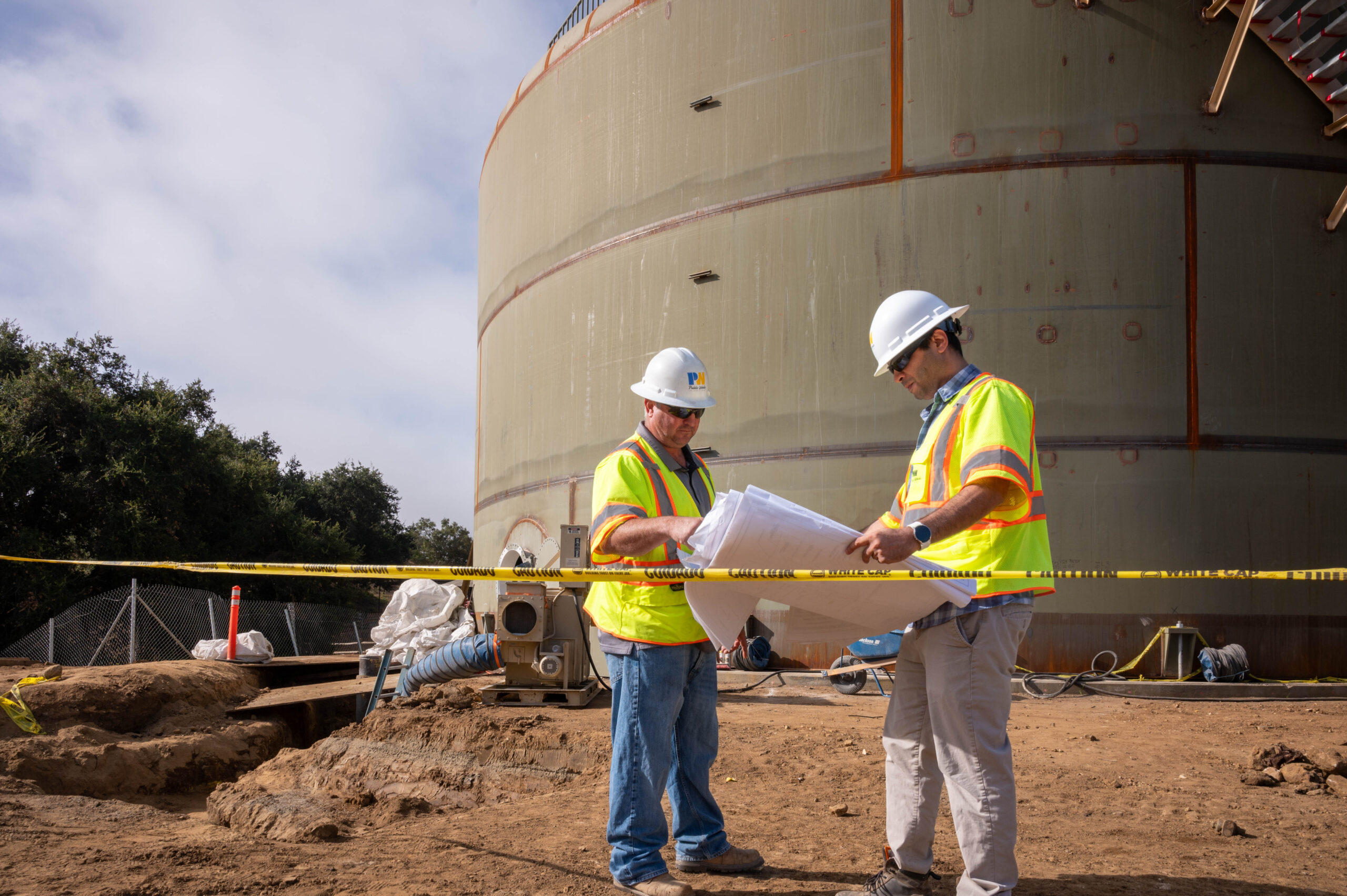 Two men in looking at plans at a construction site